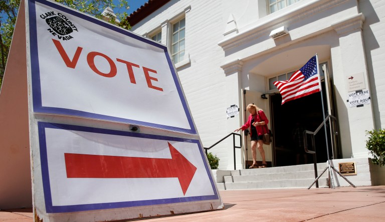 In this June 14, 2016, file photo, a woman walks out of a polling place after voting in the Nevada primary election in Las Vegas.