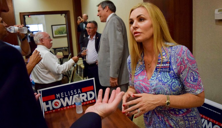 In this Tuesday, July 17, 2018 photo, Melissa Howard who is running for the District 73 State House seat being vacated by state Rep. Joe Gruters meets with voters during a "meet the candidates" event at Gold Coast Eagle Distriburing in Lakewood Ranch, Fla. Howard, a Republican candidate for the Florida Legislature who falsely claimed she had a college degree and posted a purported copy of her diploma online dropped out of her race on Tuesday, Aug. 14, 2018.  