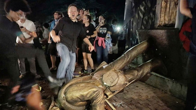 Protesters celebrate after the Confederate statue known as "Silent Sam" was toppled on the campus of the University of North Carolina in Chapel Hill.