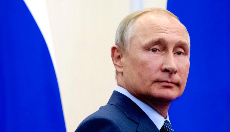 Russian President Vladimir Putin leaves the hall after a news conference.