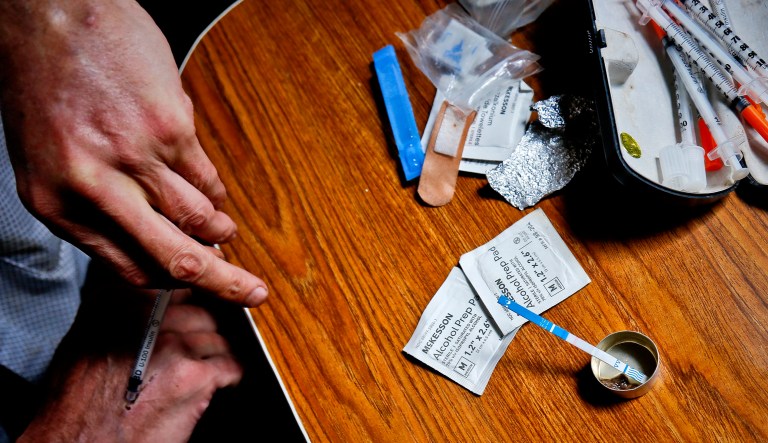 An addict injects heroin, even as a fentanyl test strip registered a positive result for contamination, Wednesday Aug. 22, 2018, in New York.