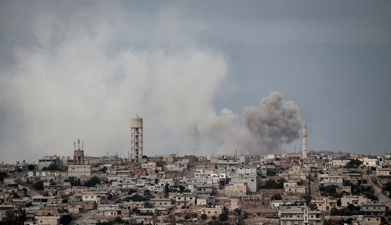Smoke rises after a TNT bomb was thrown from a helicopter, hitting a rebel position during heavy fighting between troops loyal to President Bashar Assad and opposition fighters in the Idlib province countryside, Syria, Sept. 19, 2013.
