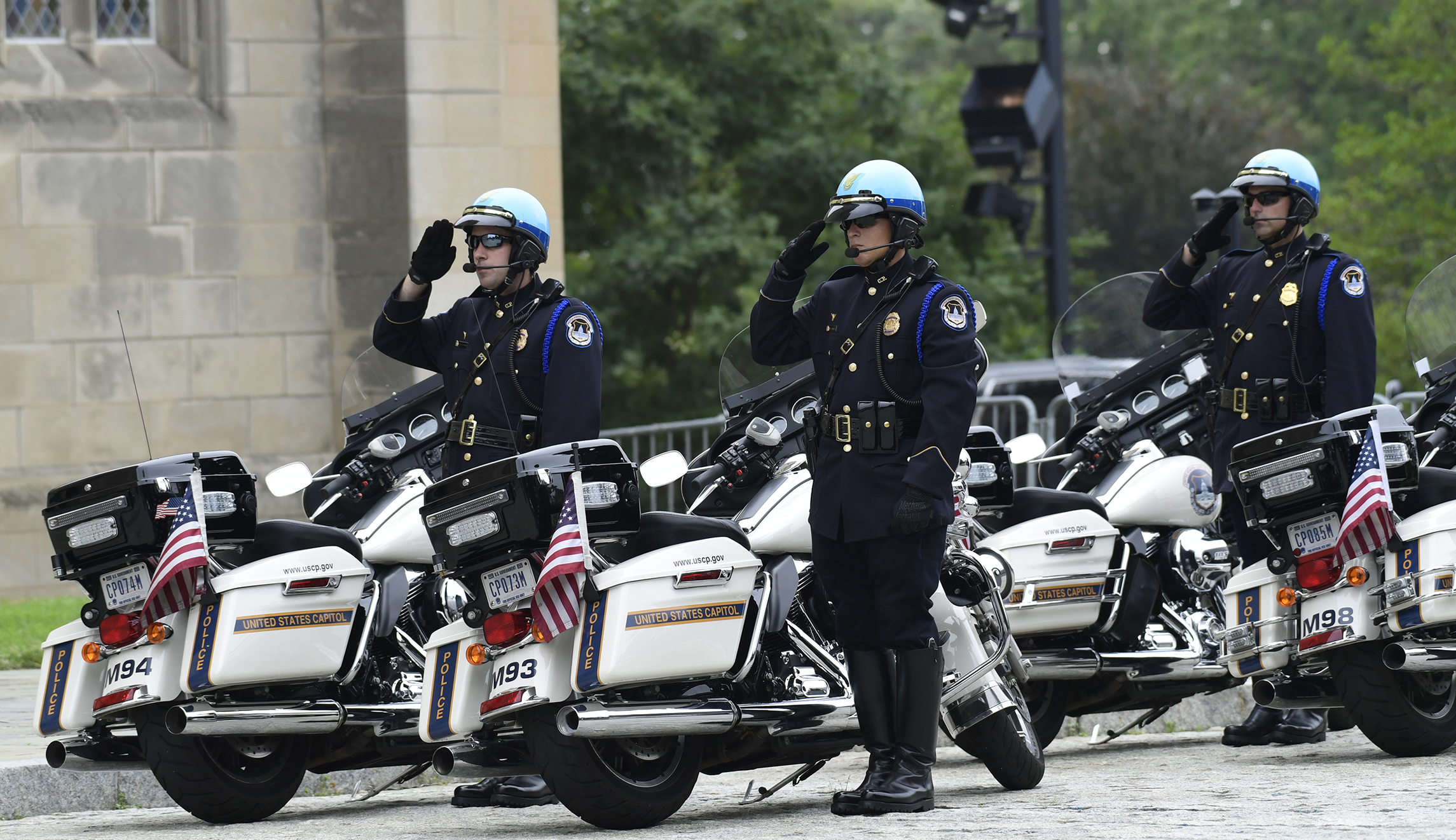 Police officers salute as the casket of Sen. John McCain, R-Ariz., arrives at the Washington National Cathedral in Washington on Saturday for a memorial service.