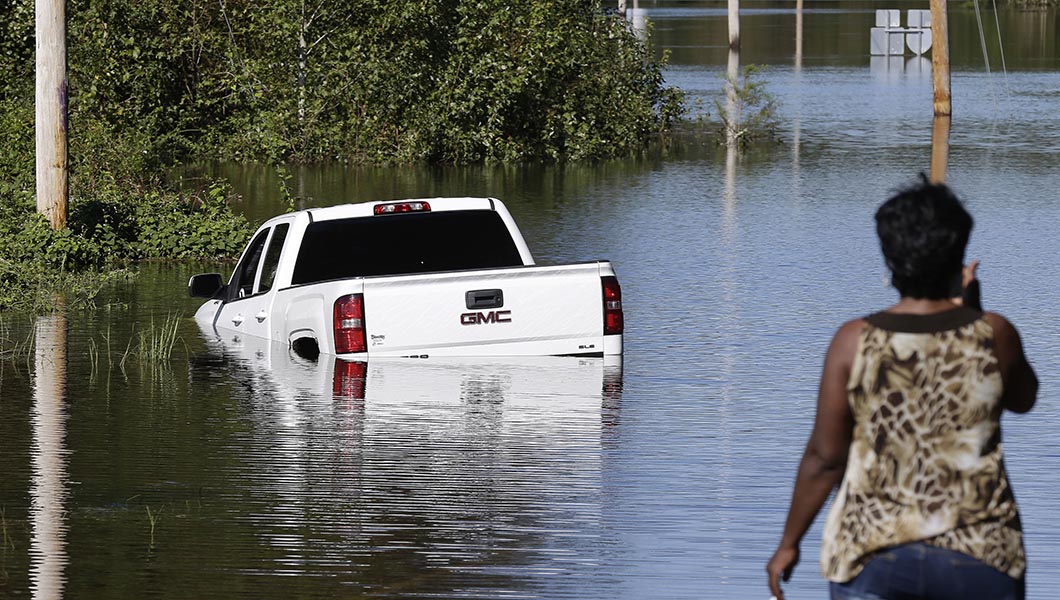 A resident surveys a road inundated by water in Lumberton, N.C.