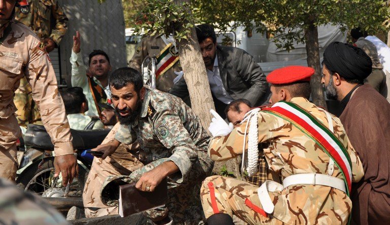 Iranian armed forces members and civilians take shelter in a shooting during a military parade marking the 38th anniversary of Iraq's 1980 invasion of Iran, in the southwestern city of Ahvaz, Iran on Saturday.
