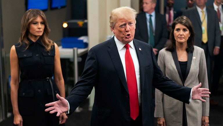 President Trump addresses members of the news media as he arrives with first lady Melania Trump, left, and Nikki Haley.