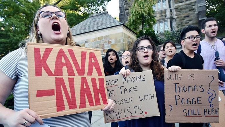 Yale University students Maryanne Cosgrove, Anna Blech, and Douglas Shao, attend a rally at the Women's Table on campus in New Haven, Conn.