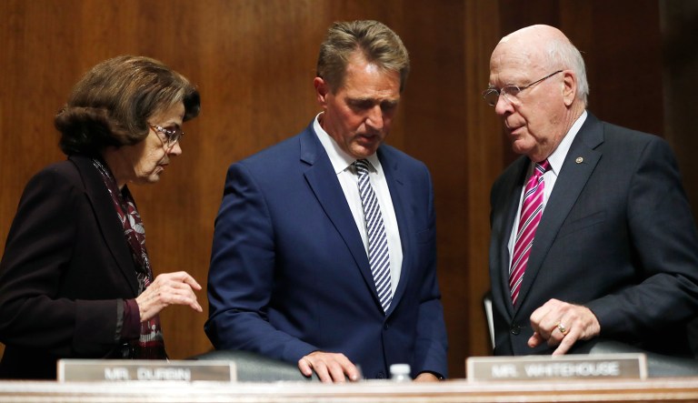 Sen. Jeff Flake, R-Ariz., center, talks to Sen. Dianne Feinstein, D-Calif, left, and Sen. Patrick Leahy, D-Vt., during a delay in the Senate Judiciary Committee hearing on Friday in Washington, D.C.