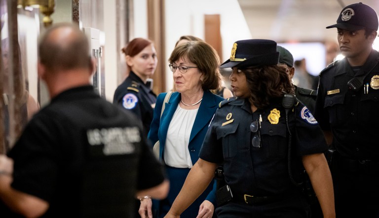 Sen. Susan Collins, R-Maine, is escorted by U.S. Capitol Police past waiting reporters trying to ask about Supreme Court nominee Brett Kavanaugh on Capitol Hill in Washington, D.C.