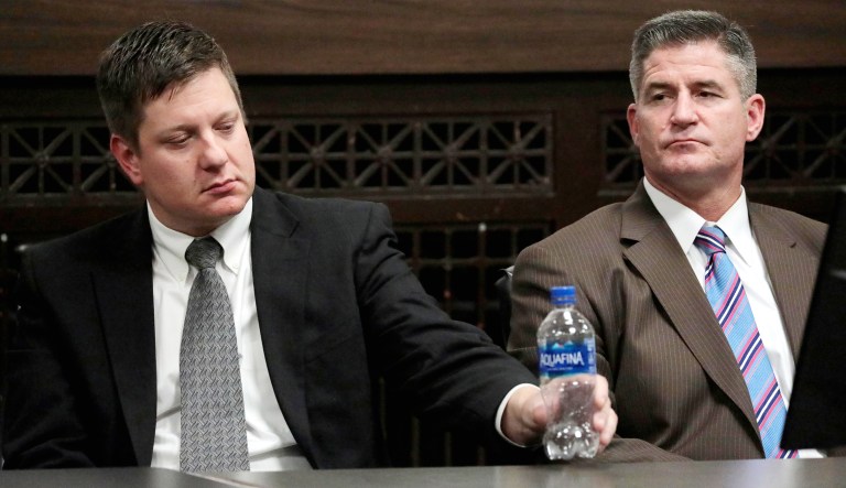 Chicago police Officer Jason Van Dyke (left) and his lead attorney, Daniel Herbert, react after jurors found him guilty of second-degree murder and aggravated battery in the 2014 shooting of black teenager Laquan McDonald on Friday at the Leighton Criminal Court Building in Chicago. 