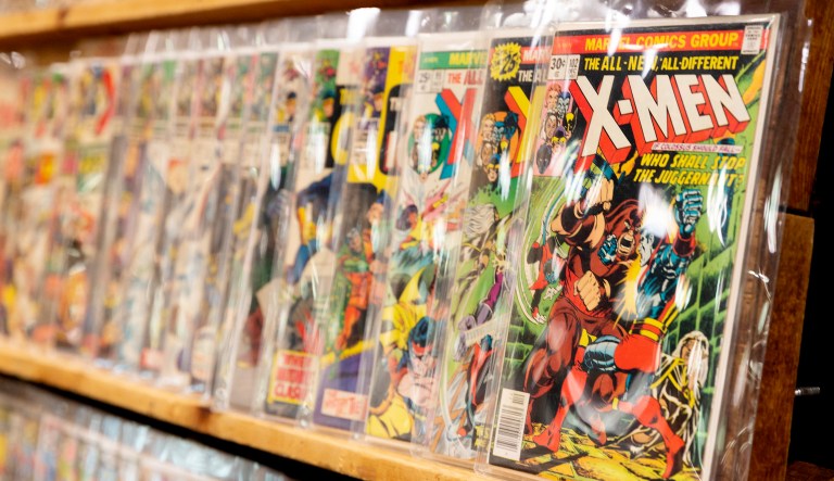 Comic books sit on a shelf.