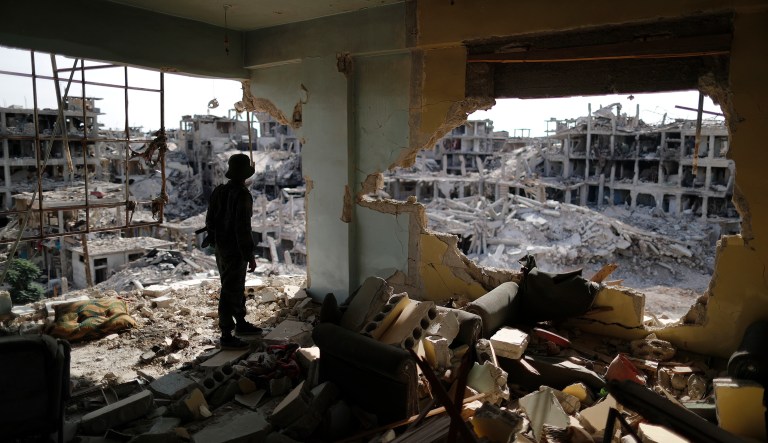 A Syrian soldier stands guard inside a destroyed apartment in the Palestinian refugee camp of Yarmouk in the Syrian capital Damascus, Syria, Saturday, Oct. 6, 2018. Bulldozers and trucks are working to clear tons of rubble from the main streets. The camp, once home to the largest concentration of Palestinians outside the territories housing nearly 160,000 people, has been gutted by years of war. 