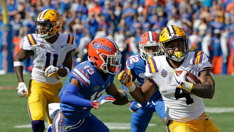 LSU running back Nick Brossette, right, runs for a gain before he is tackled by Florida safety Donovan Stiner (13) during the first half of an NCAA college football game.