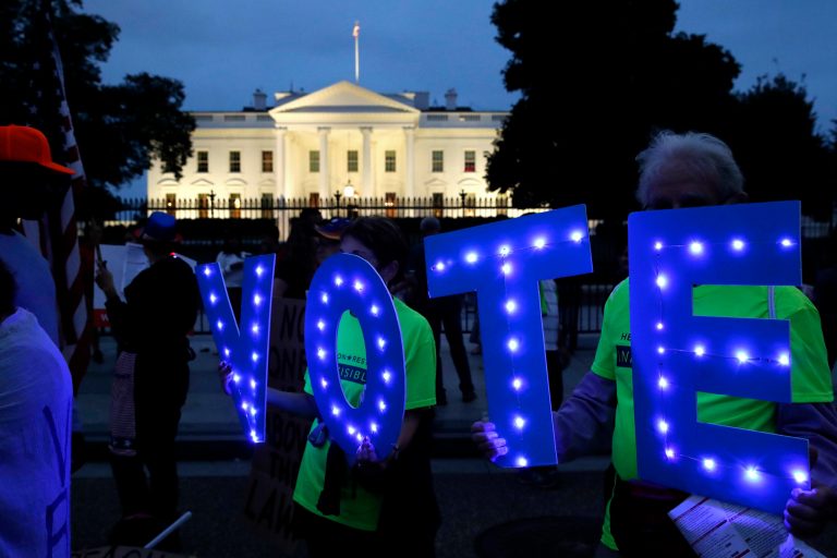 Sharon Canner, 75, and her husband Steve Canner, 81, of Reston, Va., hold up letters spelling "VOTE" during a protest of the confirmation of Brett Kavanaugh to the Supreme Court with the group Herndon Reston Indivisible, Saturday, Oct. 6, 2018, outside of the White House in Washington.