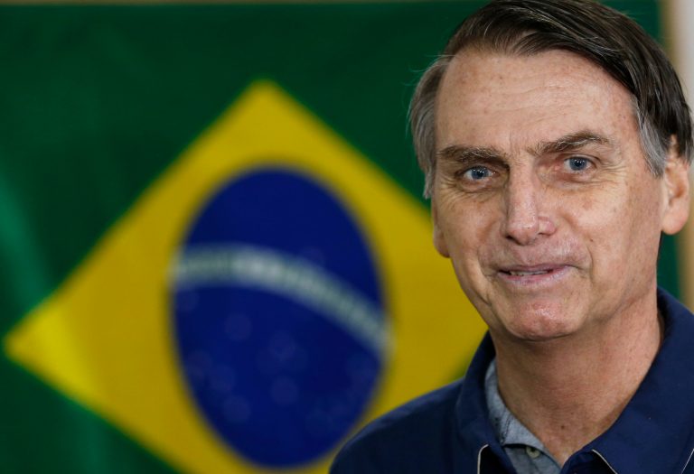 Presidential frontrunner Jair Bolsonaro, of the Social Liberal Party,  smiles a s he arrives to vote in the general election, in Rio de Janeiro, Brazil, Sunday, Oct. 7, 2018. He leads in the upcoming runoff.