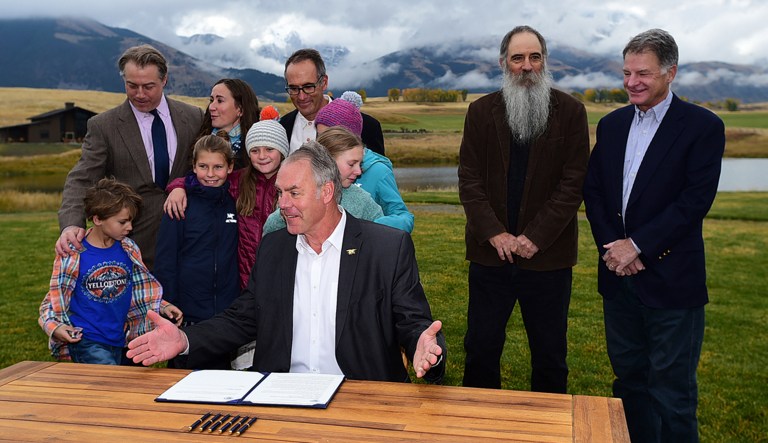 U.S. Interior Secretary Ryan Zinke, center, is surrounded by residents, business people and family members as he signs a 20-year mining moratorium on lands in Paradise Valley, Mont. on Monday, Oct. 8, 2018 at Sage Resort in Pray, Mont.  Zinke approved a 20-year ban on new mining claims in the mountains north of Yellowstone National Park after two proposed gold mines raised concerns the area could be spoiled.