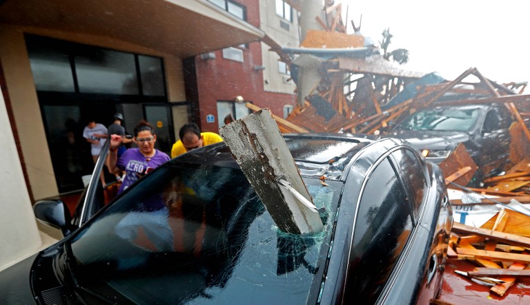 A woman checks on her vehicle as Hurricane Michael passes through, after the hotel canopy had just collapsed, in Panama City Beach, Fla., Wednesday.