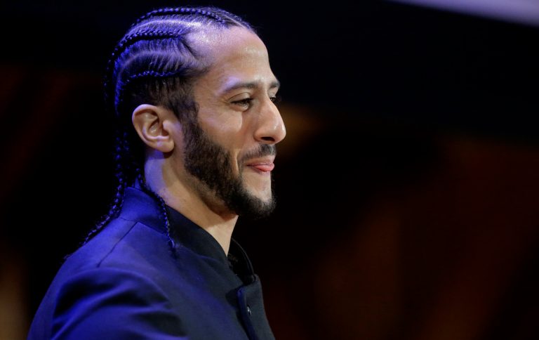 Former NFL football quarterback Colin Kaepernick steps on stage at the start of W.E.B. Du Bois Medal ceremonies, Thursday, Oct. 11, 2018, at Harvard University, in Cambridge, Mass. Kaepernick is among eight recipients of Harvard University's W.E.B. Du Bois Medals in 2018. He ranks second behind President Trump of those gamblers feel will be this year's Time 2018 Person of the the Year.