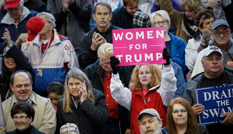 A supporter of President Trump holds a sign that reads "WOMEN FOR TRUMP" at a rally endorsing the Republican ticket, Friday, Oct. 12, 2018, in Lebanon, Ohio.