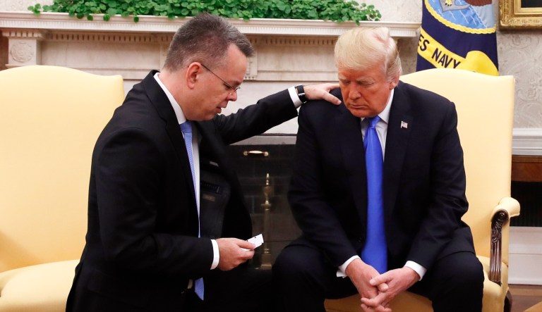 President Trump prays with American pastor Andrew Brunson in the Oval Office of the White House on Saturday in Washington. Brunson returned to the U.S. around midday after he was freed Friday from nearly two years of detention in Turkey.
