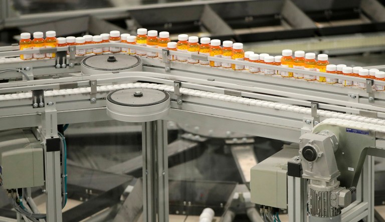 FILE- In this July 10, 2018, file photo bottles of medicine ride on a belt at the Express Scripts mail-in pharmacy warehouse in Florence, N.J. On Monday, Oct. 15, the industry's largest trade group announced that dozens of drugmakers will start disclosing the prices for U.S. prescription drugs advertised on TV. The prices won't actually be shown in the TV commercials but the advertisement will include a website where the list price will be posted. 
