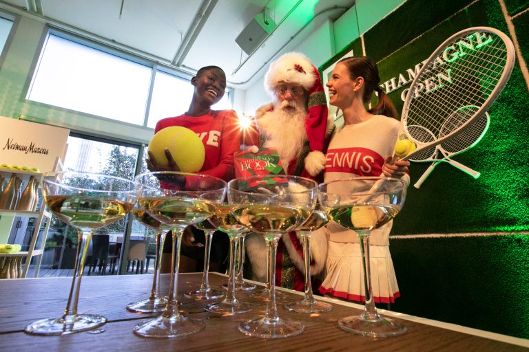 Brady White, dressed as Santa, is flanked by models presenting the Tennis Majors experience during a preview of the Neiman Marcus Christmas Book in New York, Thursday, Oct. 18, 2018. For $555,000, you can be the VIP of tennis great Sloane Stephens, winner of the U.S. Open last year.