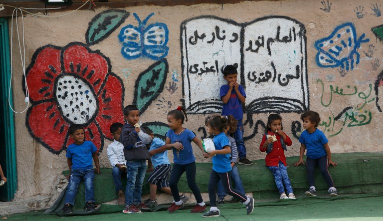 Palestinians sit outside their school in the West Bank Bedouin community of Khan al-Ahmar, Sunday, Oct. 21, 2018.