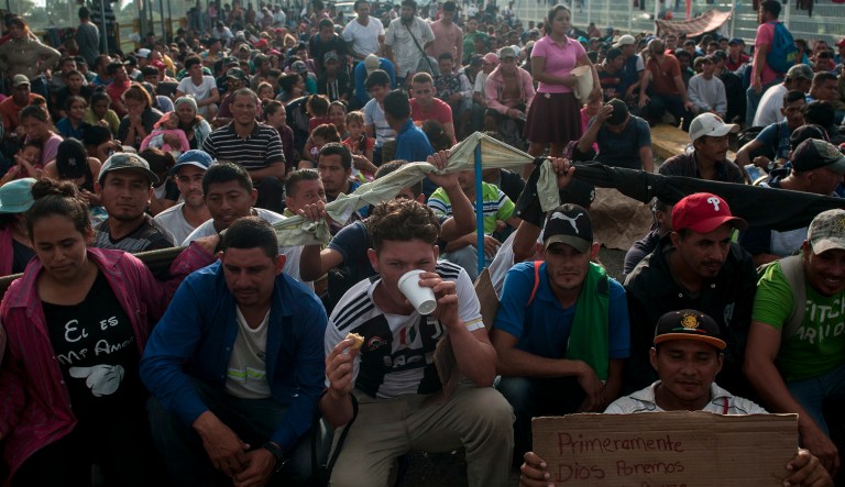 Honduras migrants wait to be attended by Mexican migration authorities on a bridge that stretches over the Suchiate River, connecting Guatemala and Mexico, in Tecun Uman, Guatemala, Sunday, Oct. 21, 2018. Despite Mexican efforts to stop them at the border, about 5,000 Central American migrants resumed their advance toward the U.S. border early Sunday in southern Mexico.
