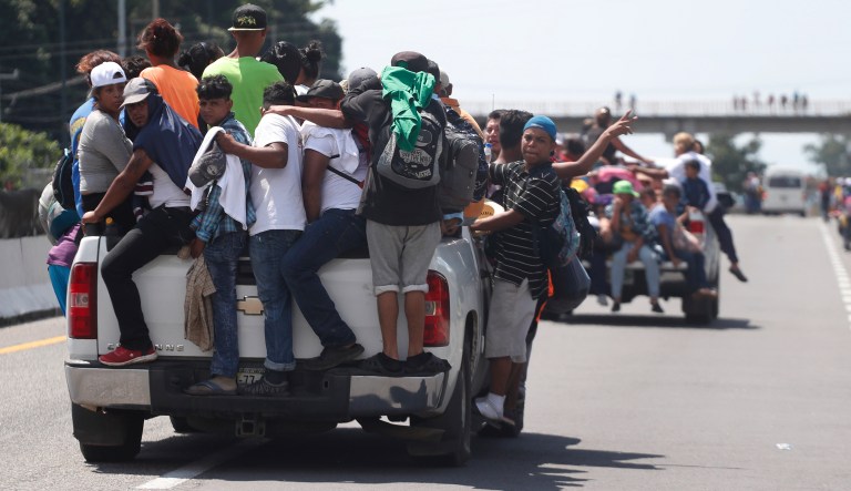 Central American migrants making their way to the U.S. in a large caravan cling to the trucks of drivers who offered them free rides, as they arrive to Tapachula, Mexico, Sunday, Oct. 21, 2018. Despite Mexican efforts to stop them at the Guatemala-Mexico border, about 5,000 Central American migrants resumed their advance toward the U.S. border Sunday in southern Mexico.