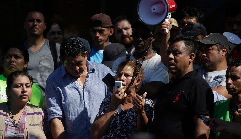 Honduran migrant Elena Lourdes Urbina speaks to reporters using a megaphone in Tapachula, Mexico, Monday, Oct. 22, 2018. Thousands of Central American migrants resumed an arduous trek toward the U.S. border Monday, with many bristling at suggestions there could be terrorists among them and saying the caravan is being used for political ends by U.S. President Donald Trump.
