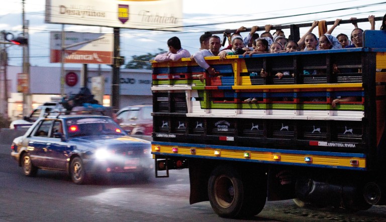 Commuters ride in the back of a pickup as night falls in San Miguel, El Salvador.
