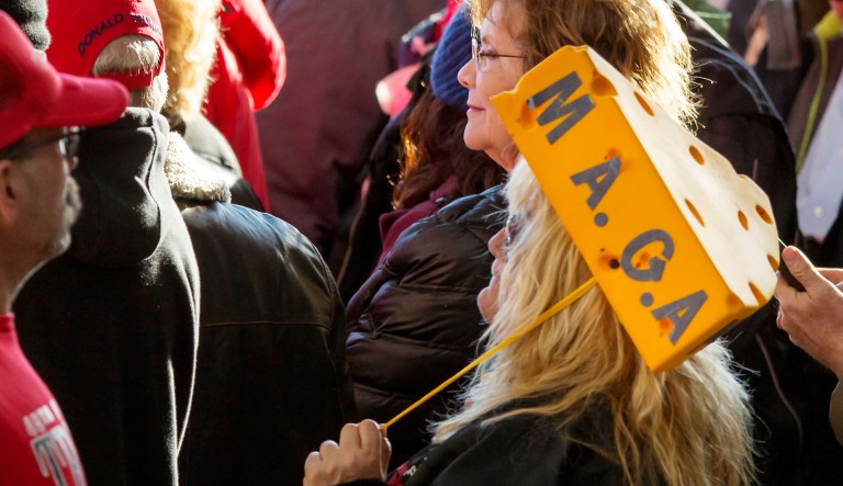 A President Trump supporter wears a cheese head hat promoting the Make America Great Again slogan before a rally in Wisconsin.