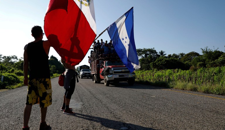 Honduran migrants walking north wave the flags of Honduras and Mexico to passing trucks carrying migrants, as a thousands strong caravan heads north trying to reach the U.S., still over 1000 miles away, near Mapastepec, Mexico, Thursday, Oct. 25, 2018.