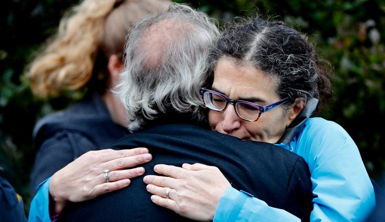 People embrace along the street in the Squirrel Hill neighborhood of Pittsburgh where a shooter opened fire during services at the Tree of Life Synagogue on Saturday.