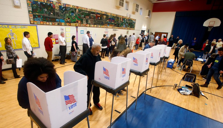 Voters fill out their ballots and wait in long lines to vote in Short Pump, Va.