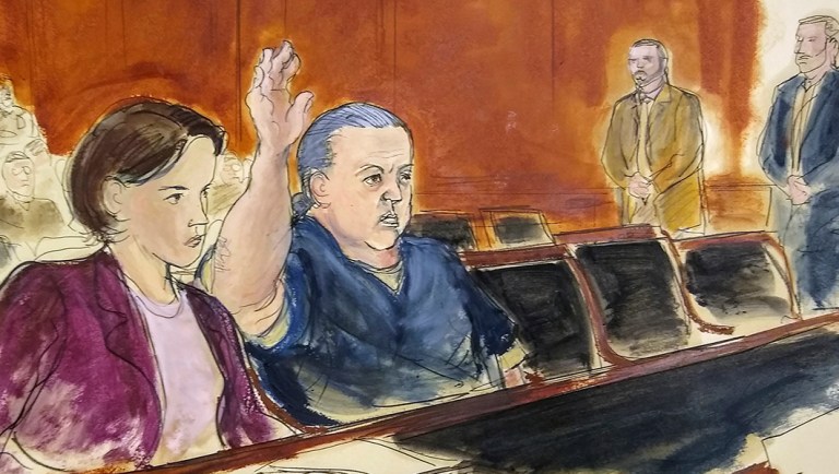 In this courtroom sketch, pipe bombs suspect Cesar Sayoc seated in court, raises his arm to swear to the truth of his statement.
