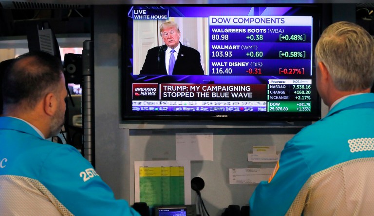 Specialists on the floor of the New York Stock Exchange watch President Trump's news conference, Wednesday, Nov. 7, 2018.