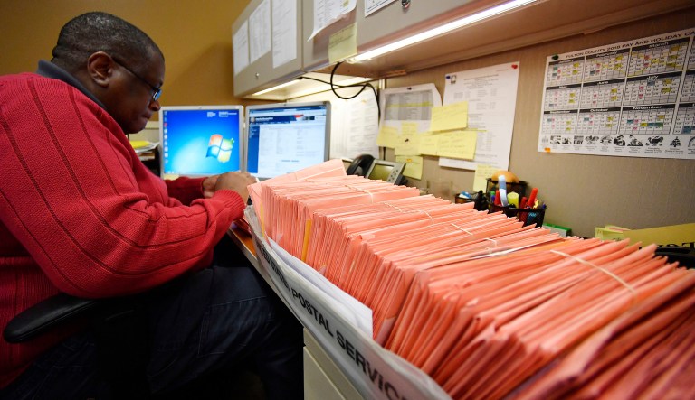 A Fulton County election worker counts provisional ballots, Wednesday, Nov. 7, 2018, in Atlanta. Malfunctioning voting machines, missing power cords, and hours-long lines at the polls are being scrutinized in Georgia, where the governor's race is still undecided as votes are still being tallied.