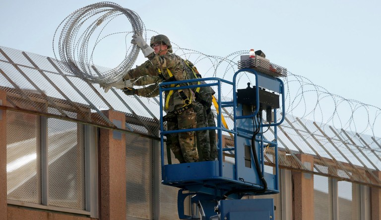 In this Nov. 7, 2018, photo, U.S. Army troops with the 16th Military Police Brigade install concertina wire atop the U.S.-Mexico border near the Morley pedestrian gate just east of the DeConcini Port of Entry in Nogales, Ariz. The brigade is comprised of troops from the 42nd Military Police Brigade and the 66nd Engineer Battalion.