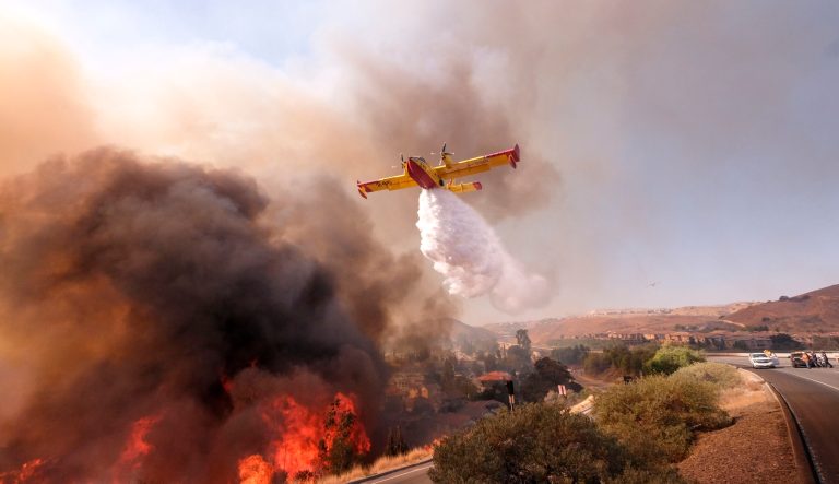 An air tanker drops water on a fire along the Ronald Reagan (118) Freeway in Simi Valley, Calif., Monday, Nov. 12, 2018. 