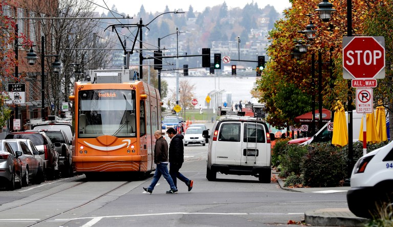 A South Lake Union streetcar with Amazon.com logo moves along a street Tuesday, Nov. 13, 2018, in Seattle's South Lake Union neighborhood where many Amazon office buildings are located. Amazon ended its competition for a second headquarters Tuesday by selecting New York and Arlington, Va., as the joint winners. 