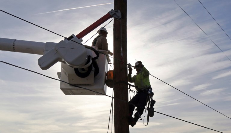 Southern California Edison crews work to replace burned power poles and lines destroyed by the Woolsey Fire over a burned-over hillside along Pacific Coast Highway in Malibu in Southern California Tuesday, Nov. 13, 2018.