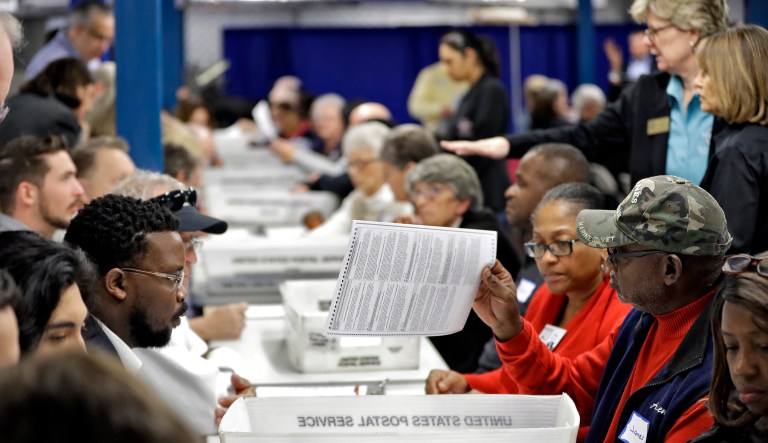 Volunteers check under and over votes during an elections manual recount for three undecided races on Friday in Tampa, Fla.
