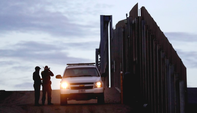 United States Border Patrol agents stand by a vehicle near one of the border walls separating Tijuana, Mexico, and San Diego in California.