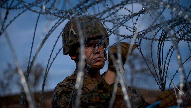 A soldier agent sets up barbed wire at the San Ysidro port of entry, at the U.S.-Mexico border.