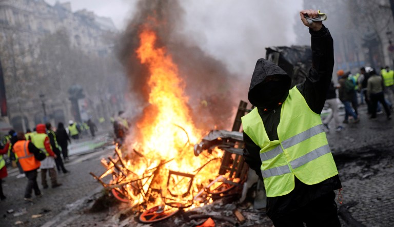 Demonstrators, called the yellow jackets, protest over the cost of fuel taxes on the famed Champs-Elysees avenue, in Paris, France, on Saturday.