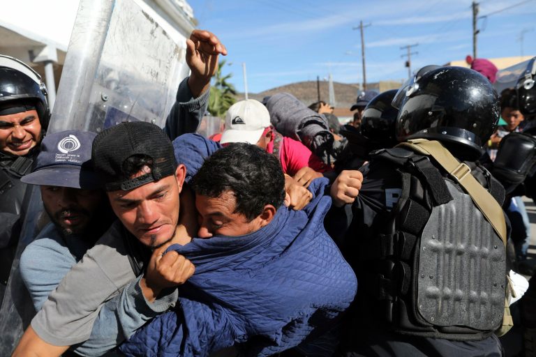 Migrants clash with Mexican police at the Mexico-U.S. border after getting past another line of Mexican police at the Chaparral crossing in Tijuana, Mexico, Sunday, Nov. 25, 2018, as they try to reach the U.S. The mayor of Tijuana has declared a humanitarian crisis in his border city and says that he has asked the United Nations for aid to deal with the approximately 5,000 Central American migrants who have arrived in the city.
