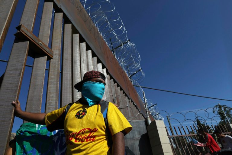 Migrants gather at the Mexico-U.S. border after getting past a line of Mexican police at the Chaparral crossing in Tijuana, Mexico, Sunday, Nov. 25, 2018, as they try to enter the U.S.