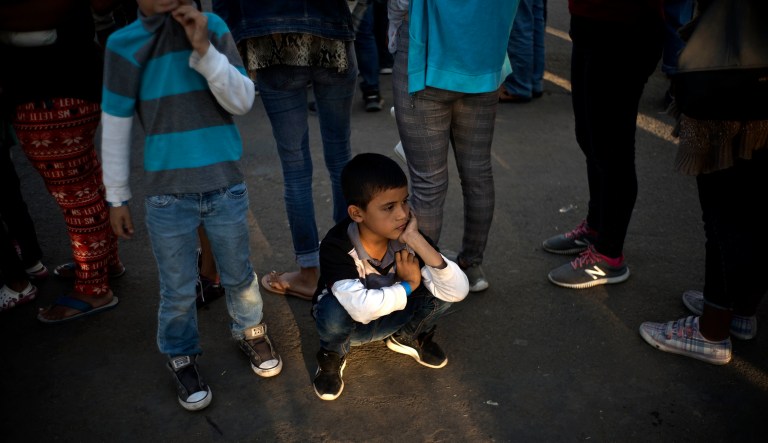 A boy waits in line to receive food at the Benito Juarez Sports Center that's serving as a temporary shelter in Tijuana, Mexico, early Monday, Nov. 26, 2018. The mayor of Tijuana has declared a humanitarian crisis in his border city and says that he has asked the United Nations for aid to deal with thousands of Central American migrants who have arrived in the city.