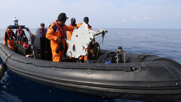 Rescuers recover a piece of airplane part from Lion Air flight 610 that crashed into the sea.
